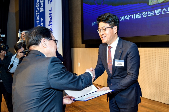 20일 박진효 네트워크기술원장(오른쪽)이 유영민 과학기술정보통신부장관으로부터 대통령상을 받고 있다. SK텔레콤 제공